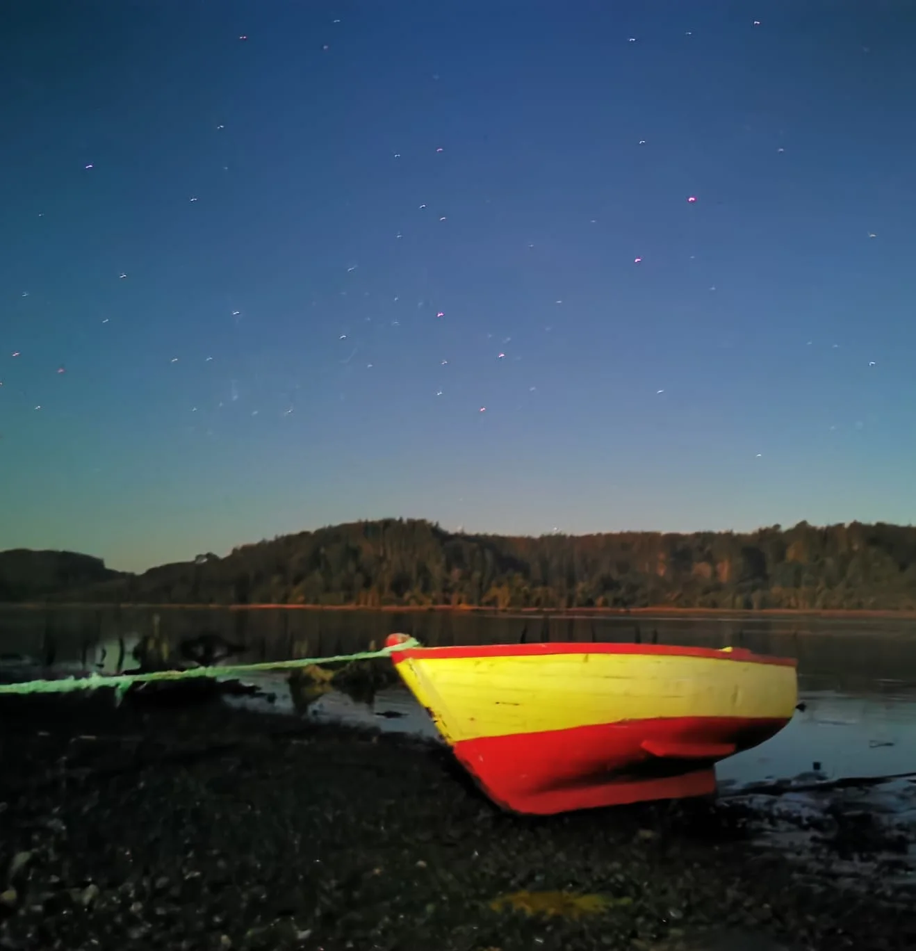 Bote junto al río bajo el cielo nocturno en Paraíso Wilkeco