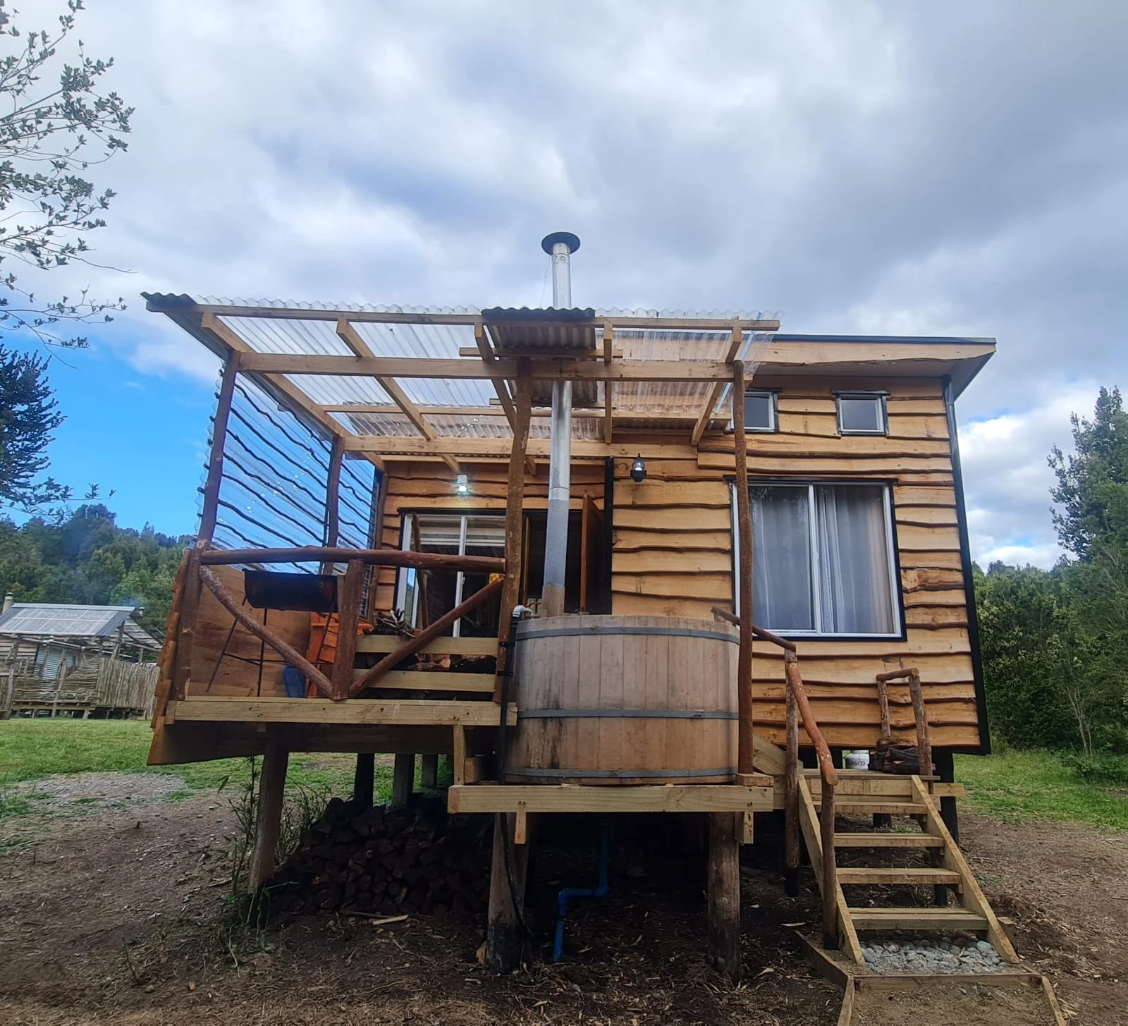 Tinaja exterior junto a una cabaña de madera en Paraíso Wilkeco
