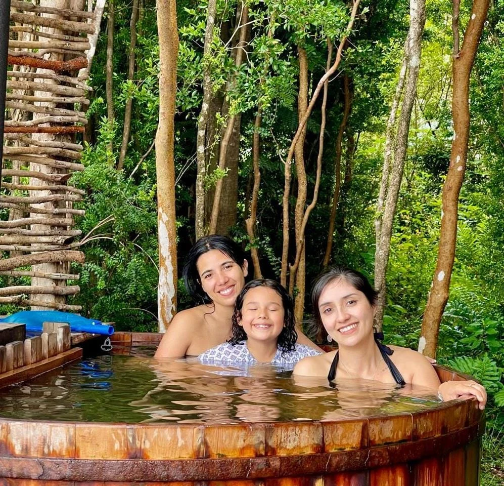 Familia disfrutando una tinaja de madera en Paraíso Wilkeco