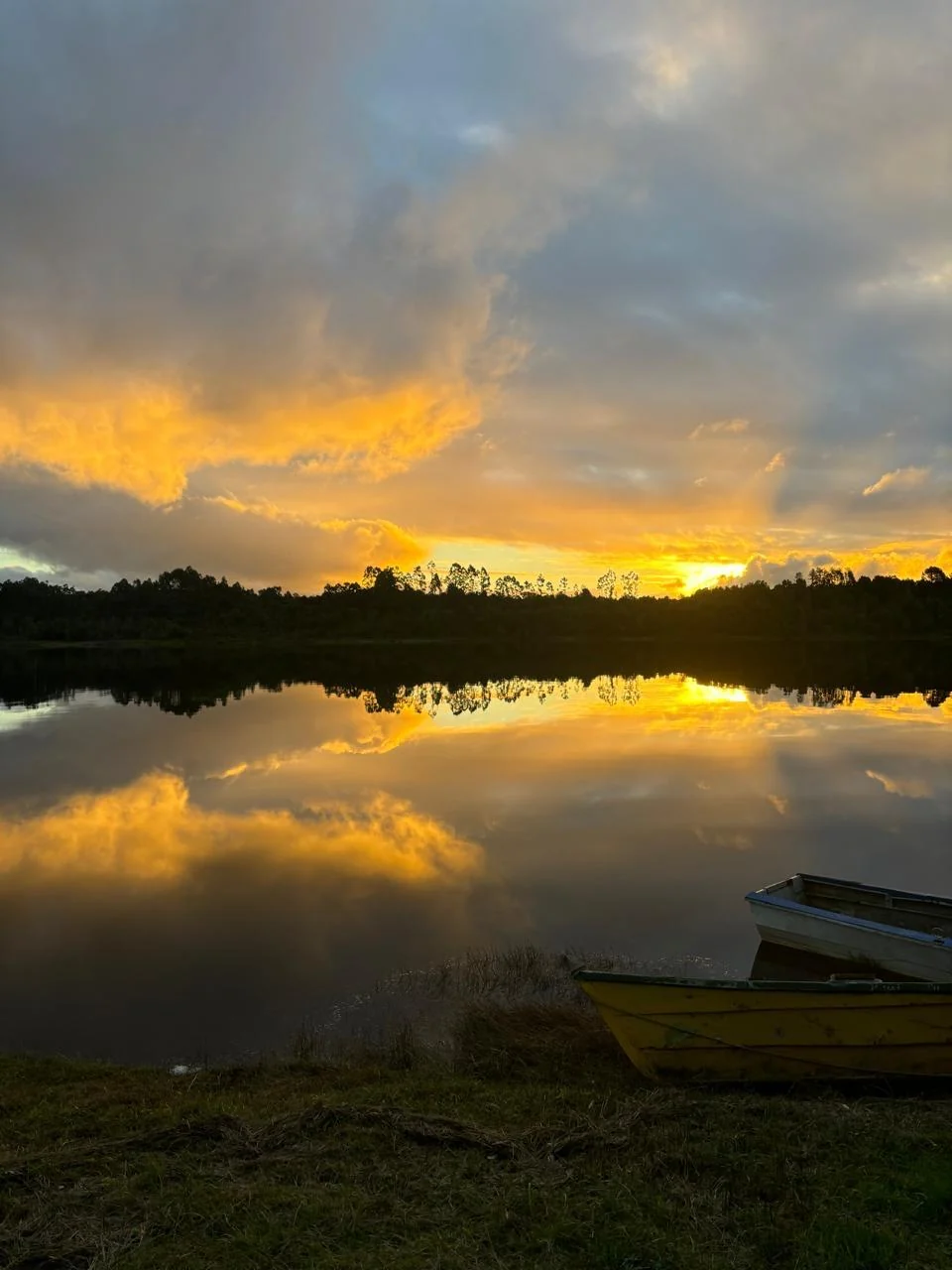 Atardecer entre nubes reflejado sobre el agua
