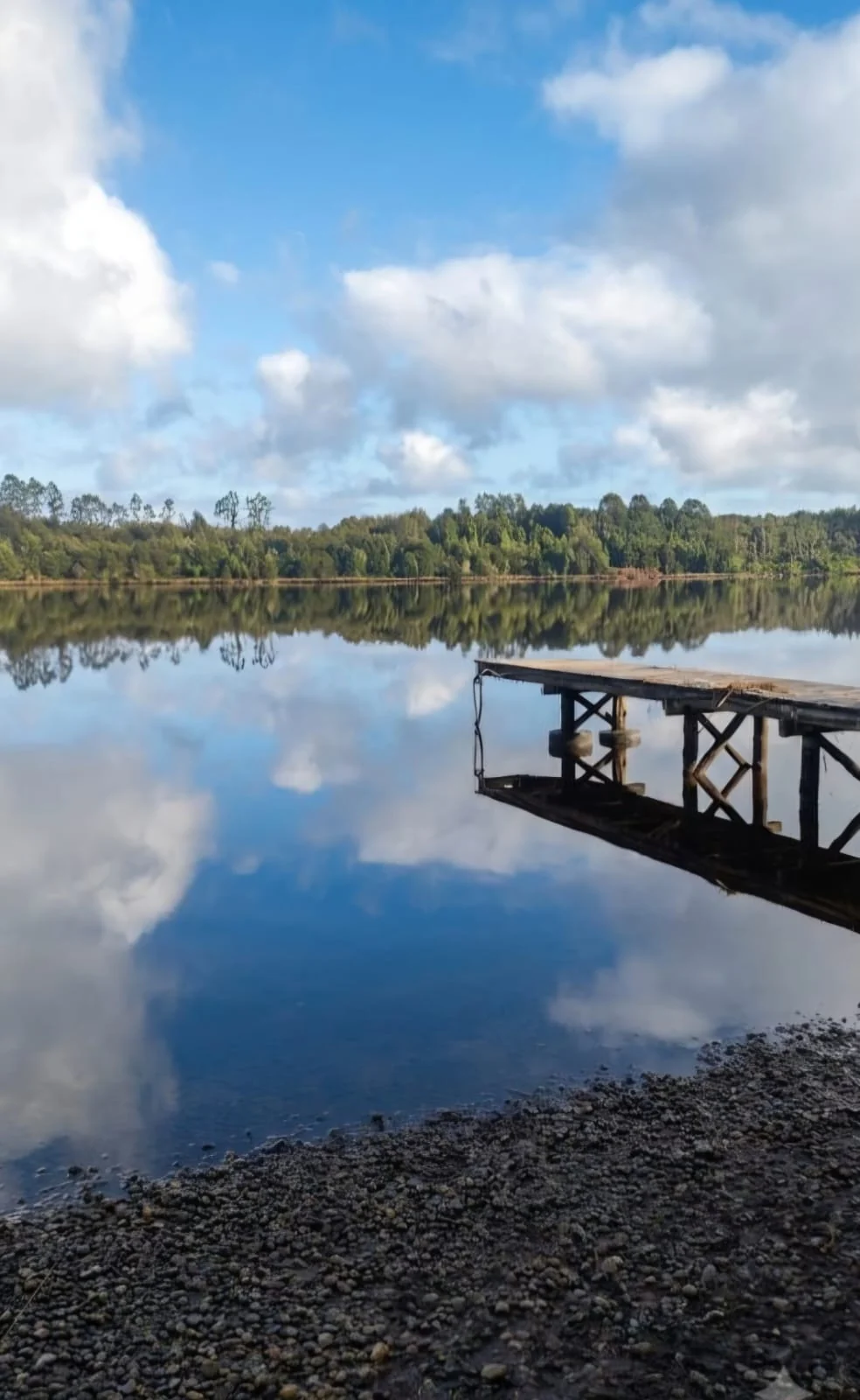 Muelle y paisaje natural bajo un cielo de nubes