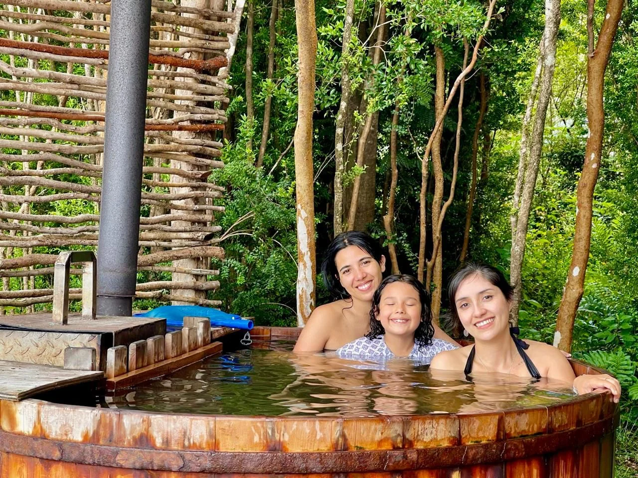 Huéspedes disfrutando una tinaja privada rodeada de bosque en Paraíso Wilkeco